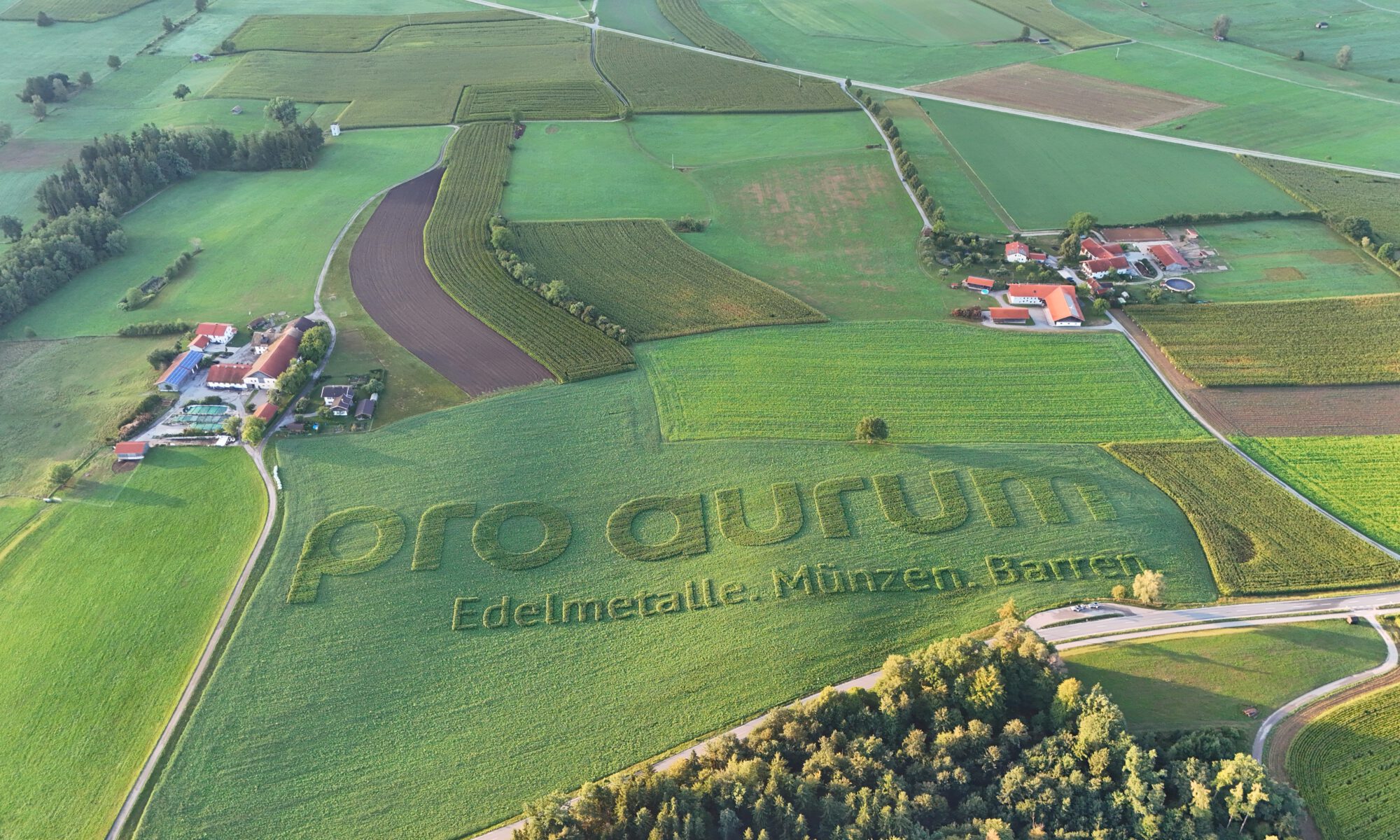 pro aurum Schriftzug als Geobranding und Ackerwerbung von GEOXIP auf einem Feld
