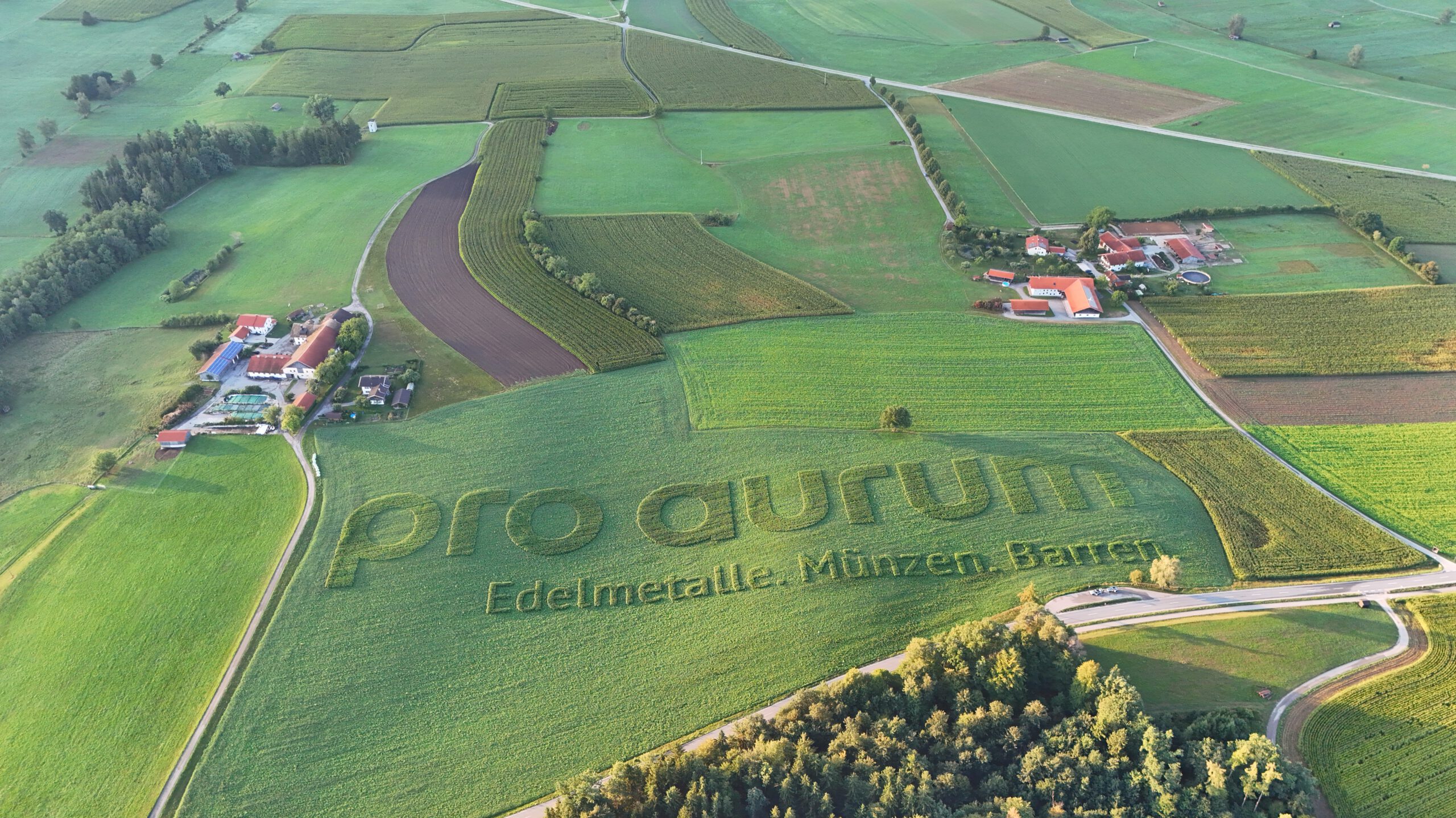 pro aurum Schriftzug als Geobranding und Ackerwerbung von GEOXIP auf einem Feld